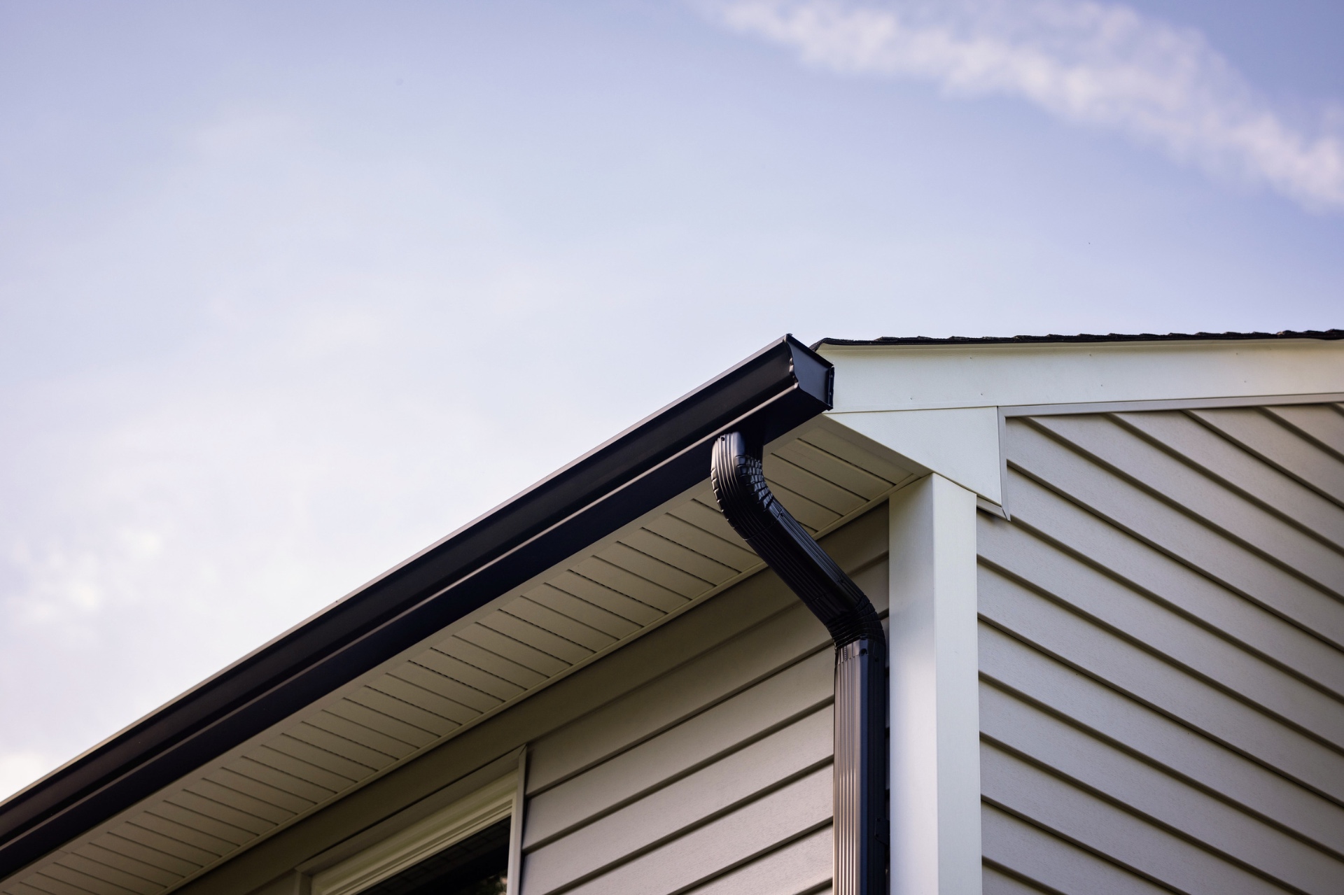 Modern black seamless gutter installation on a residential home